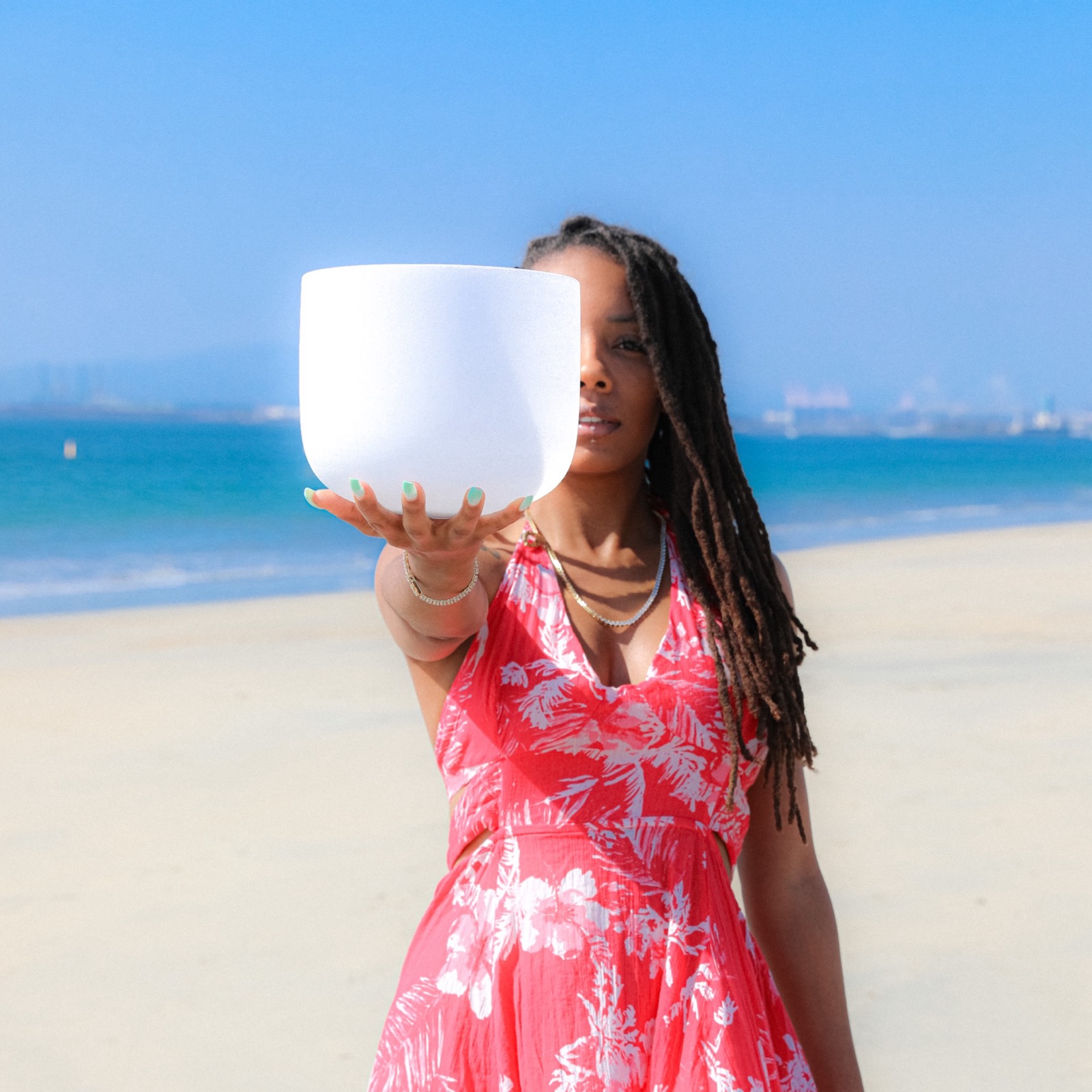 Amhara holding a crystal singing bowl on the beach