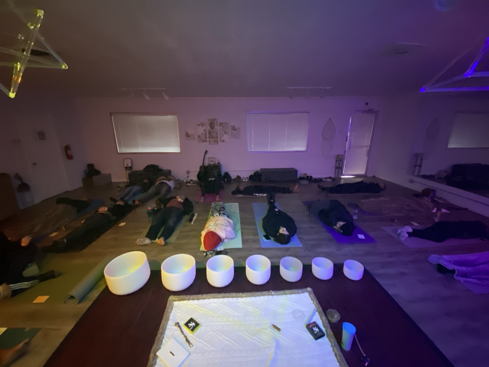 A row of crystal singing bowls set up for a sound bath session